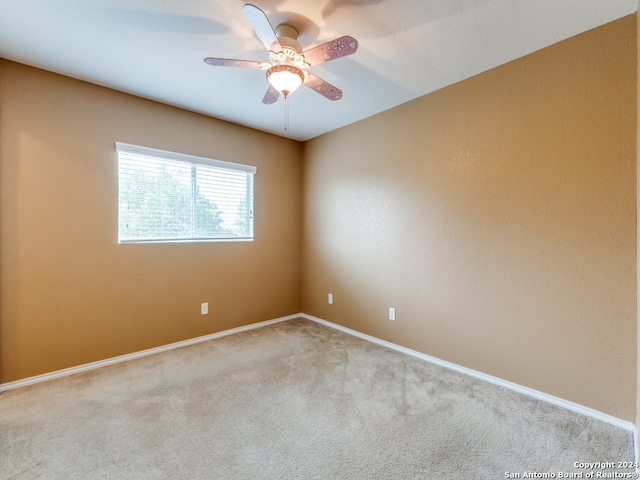 carpeted spare room with ceiling fan