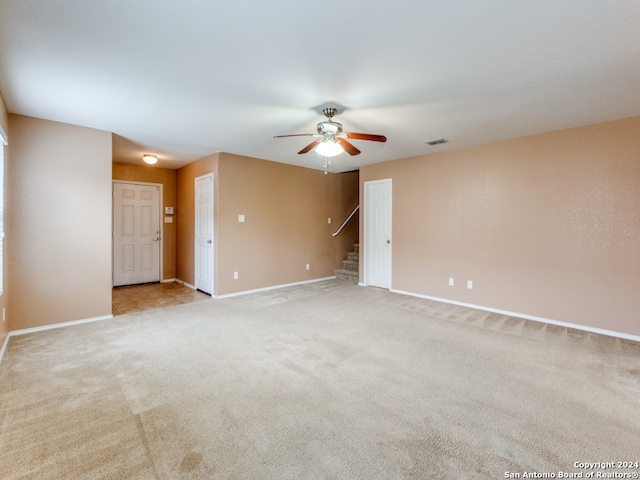 carpeted spare room with ceiling fan