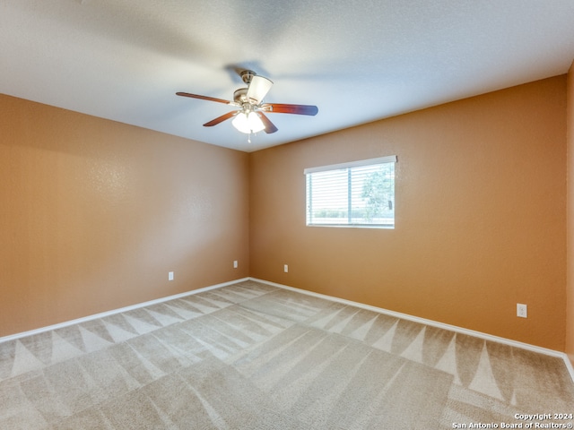 empty room with ceiling fan and carpet