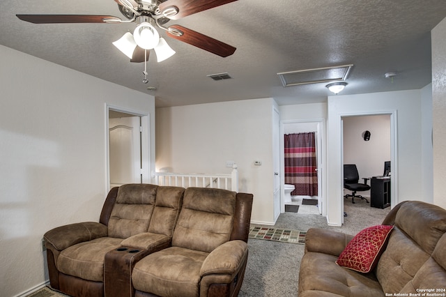 living room featuring carpet flooring, ceiling fan, and a textured ceiling