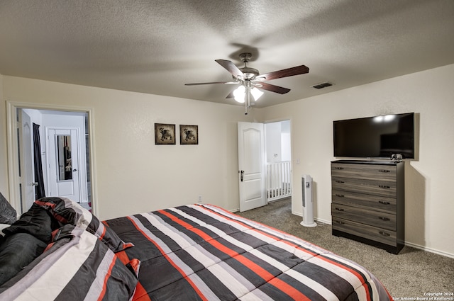 carpeted bedroom featuring a textured ceiling, ensuite bath, and ceiling fan