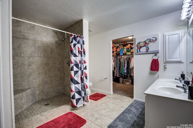 bathroom featuring a shower with curtain, tile patterned flooring, a textured ceiling, and toilet