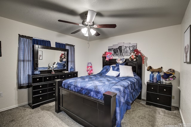 carpeted bedroom featuring ceiling fan and a textured ceiling