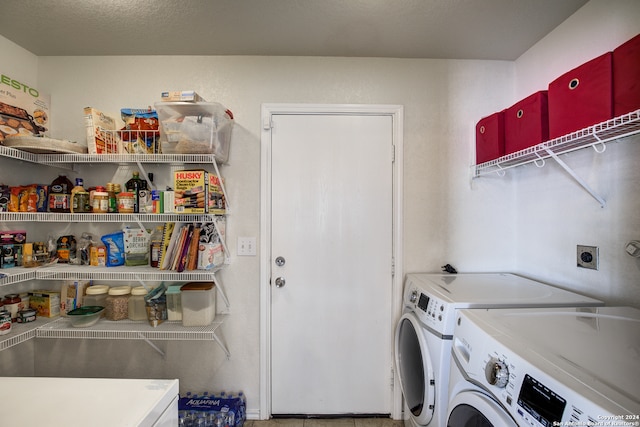 washroom featuring washing machine and clothes dryer and a textured ceiling