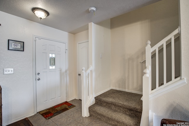 tiled entrance foyer with a textured ceiling