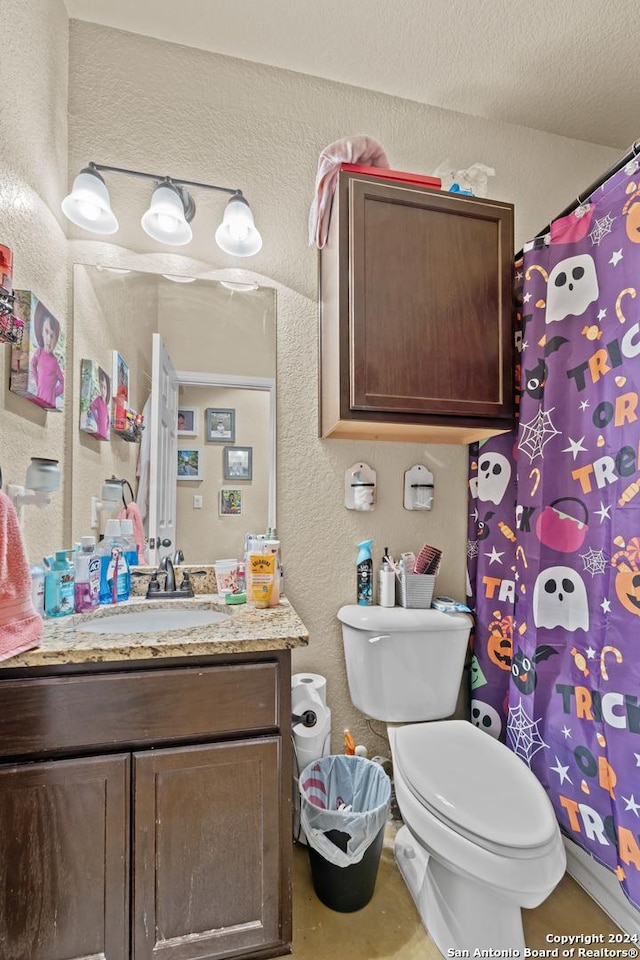 bathroom featuring vanity, a textured ceiling, and toilet