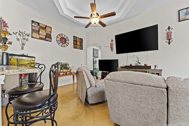 living room featuring a tray ceiling and ceiling fan