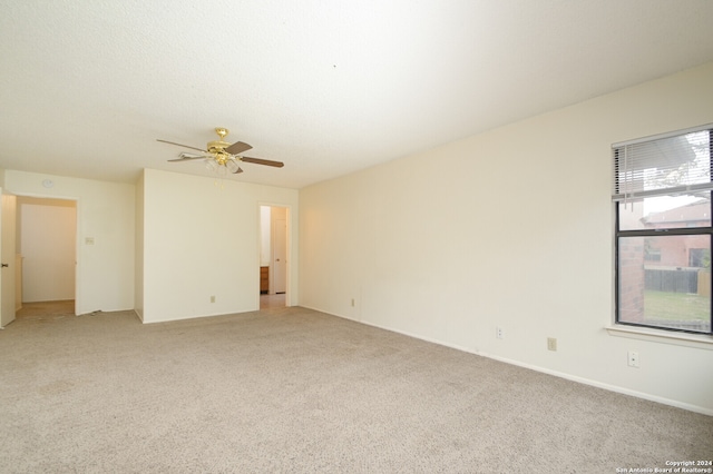 spare room featuring ceiling fan and light carpet