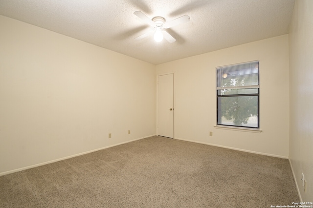 spare room featuring carpet flooring, ceiling fan, and a textured ceiling