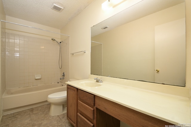 full bathroom with vanity, a textured ceiling, tile patterned flooring, toilet, and tiled shower / bath