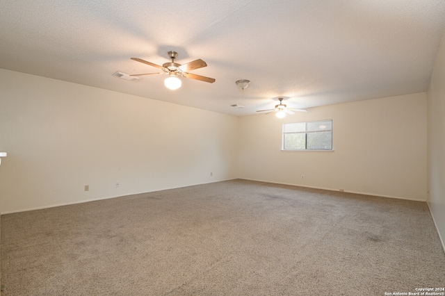 unfurnished room featuring ceiling fan, carpet floors, and a textured ceiling