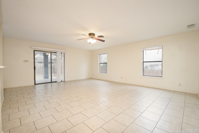 unfurnished room with ceiling fan, light tile patterned flooring, and a healthy amount of sunlight