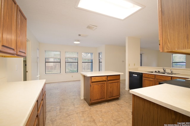 kitchen featuring sink, a center island, black dishwasher, stove, and a textured ceiling