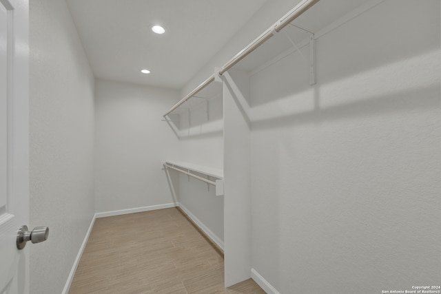 walk in closet with light wood-type flooring