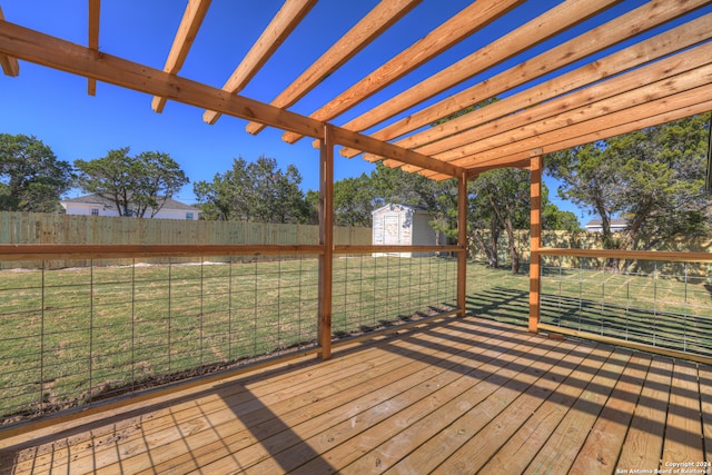 deck featuring a pergola, a storage shed, and a lawn