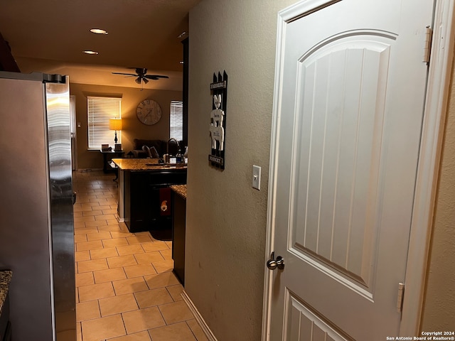 hallway with light tile patterned floors and sink