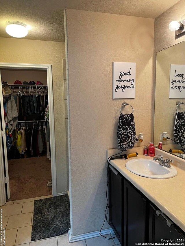 bathroom featuring tile patterned flooring, vanity, and a textured ceiling