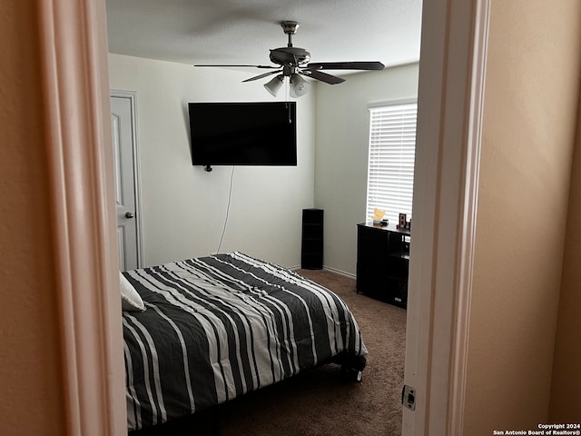 carpeted bedroom featuring ceiling fan and a textured ceiling