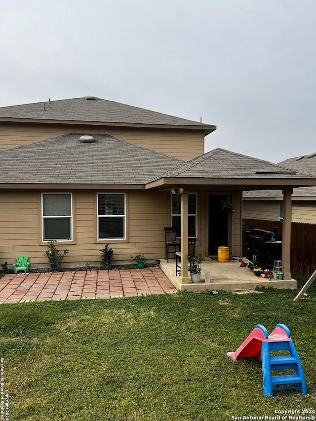 rear view of property with a lawn and a patio area