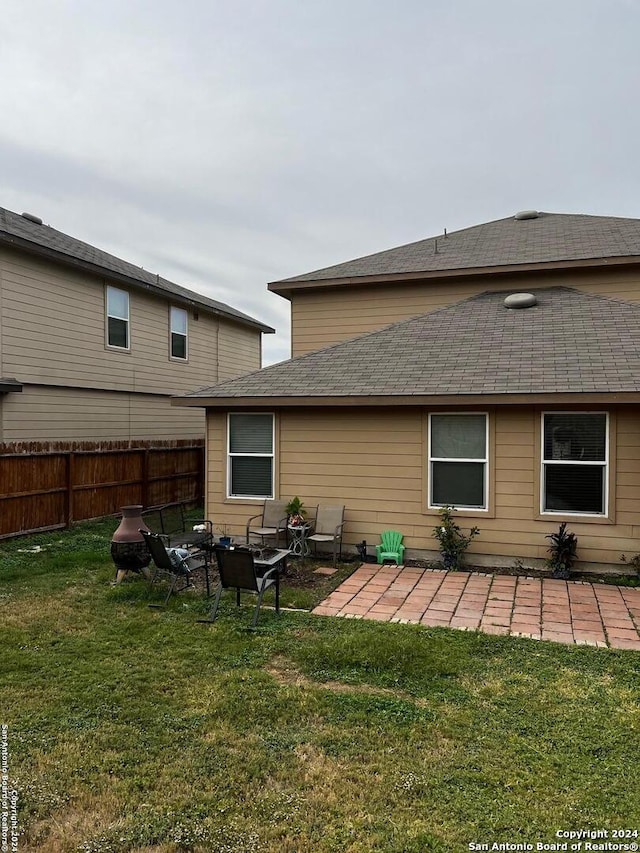 rear view of property featuring a yard and a patio