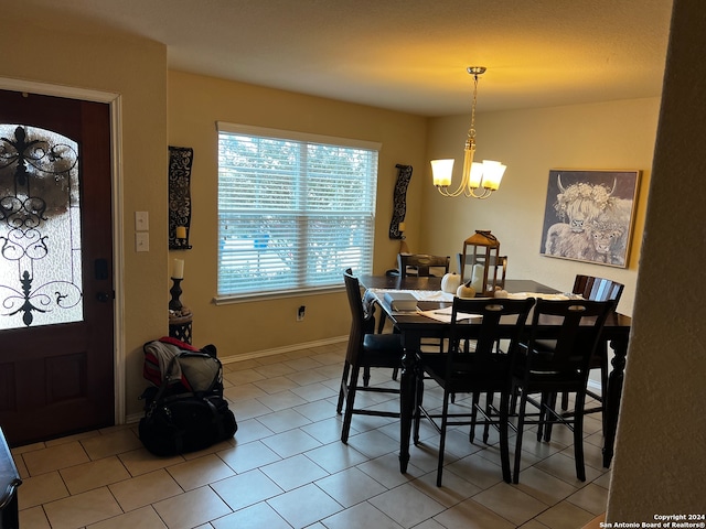 tiled dining room with an inviting chandelier