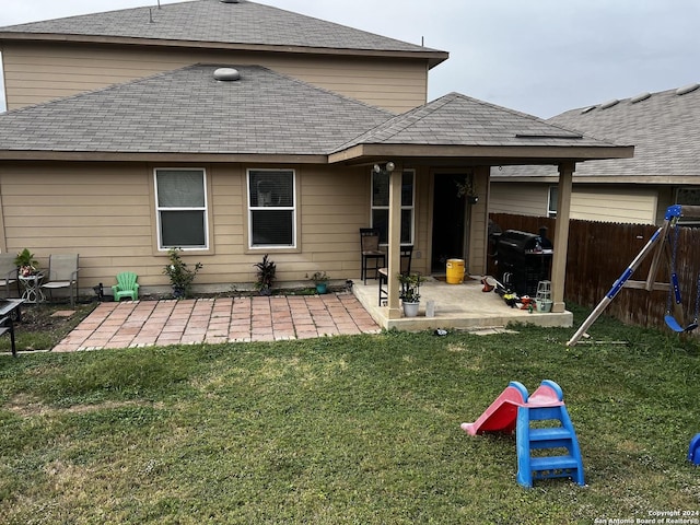 back of property with a patio and a lawn