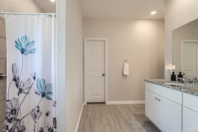 bathroom featuring wood-type flooring, vanity, and walk in shower