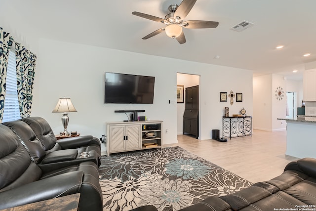 living room featuring ceiling fan and light wood-type flooring