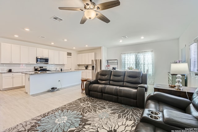 living room featuring light hardwood / wood-style floors and ceiling fan