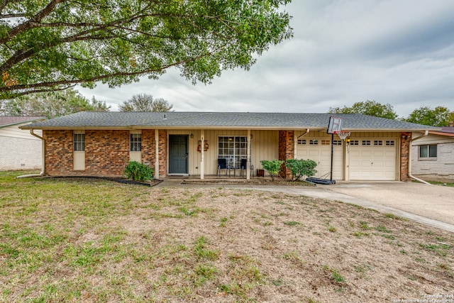 single story home with a front lawn, covered porch, and a garage