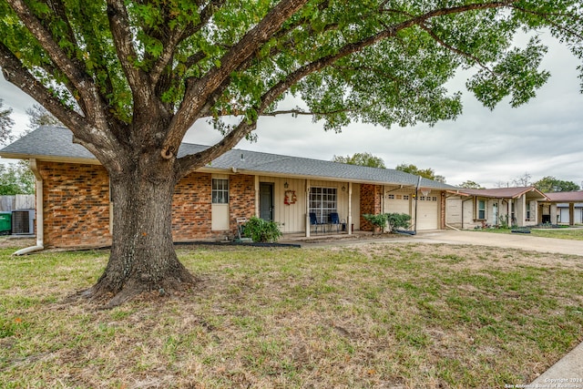 ranch-style house featuring a front lawn, central AC unit, and a garage