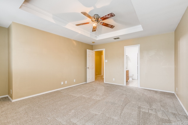 carpeted spare room featuring ceiling fan, a raised ceiling, and ornamental molding