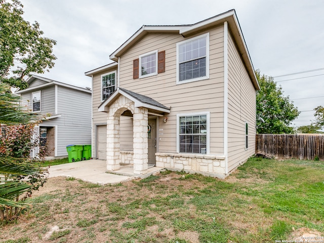 view of front of property featuring a patio, a garage, and a front lawn