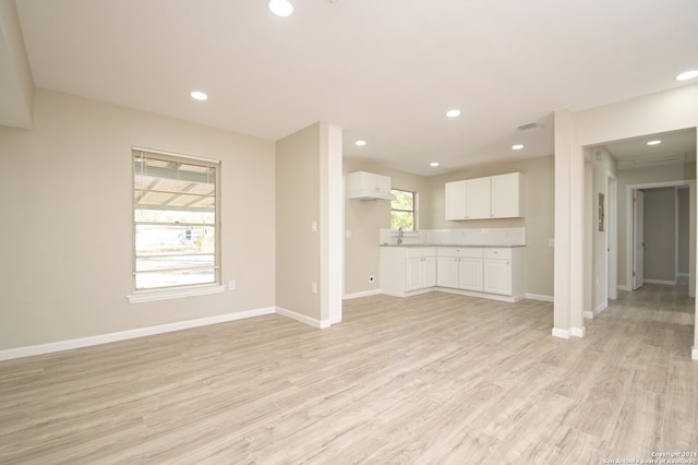 unfurnished living room with light wood-type flooring and sink