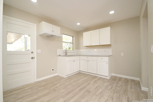 kitchen featuring white cabinets, light hardwood / wood-style floors, and a wealth of natural light