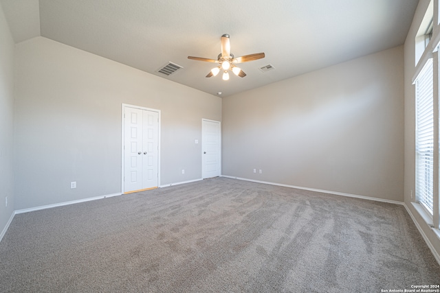 empty room with vaulted ceiling, ceiling fan, carpet, and a healthy amount of sunlight