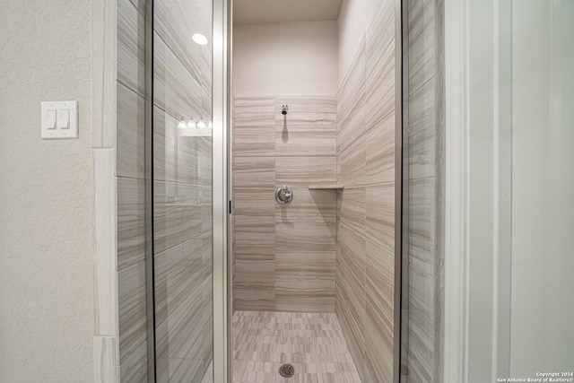 bathroom featuring a shower with door