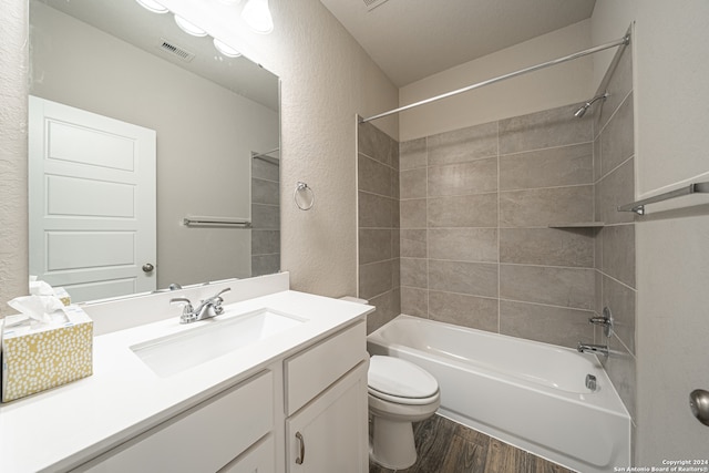 full bathroom featuring toilet, vanity, tiled shower / bath combo, and hardwood / wood-style flooring