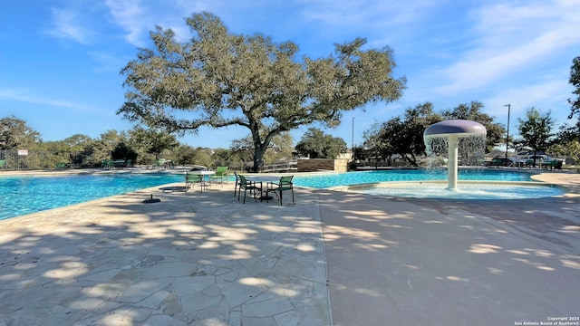 view of swimming pool featuring pool water feature and a patio area