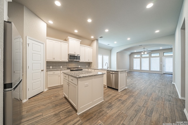 kitchen featuring stainless steel appliances, a center island, white cabinetry, and kitchen peninsula