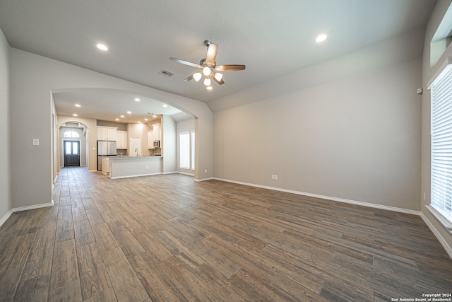 unfurnished living room with ceiling fan, sink, lofted ceiling, and dark hardwood / wood-style floors