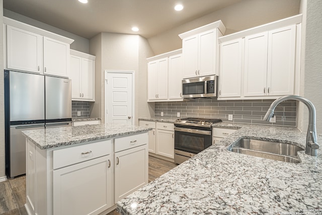 kitchen featuring white cabinets, appliances with stainless steel finishes, backsplash, and sink