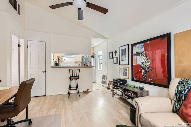 home office featuring ceiling fan, light wood-type flooring, and vaulted ceiling