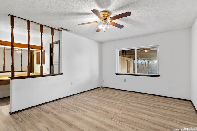 spare room with ceiling fan, light wood-type flooring, and a textured ceiling