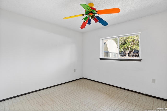 empty room with ceiling fan and a textured ceiling