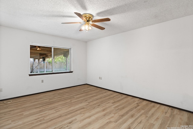 unfurnished room with ceiling fan, a textured ceiling, and light wood-type flooring