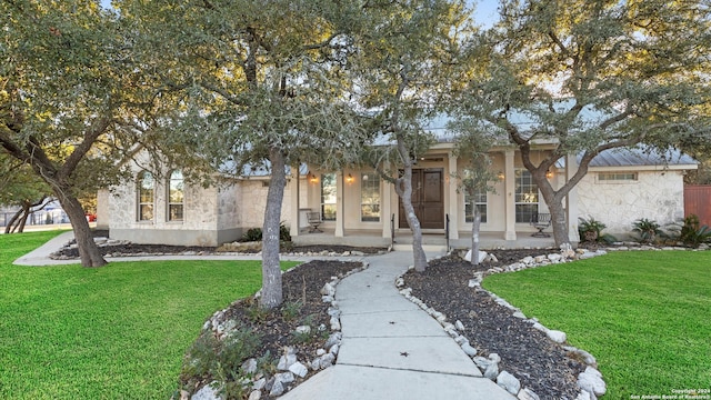 view of front of home with covered porch and a front lawn