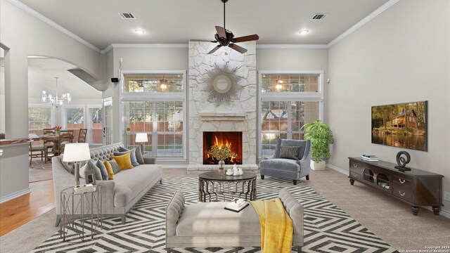 living room featuring ceiling fan with notable chandelier, light hardwood / wood-style floors, a stone fireplace, and ornamental molding