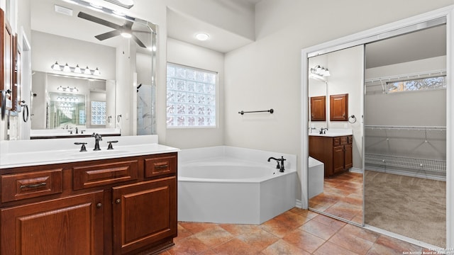 bathroom featuring tile patterned floors, vanity, ceiling fan, and a tub