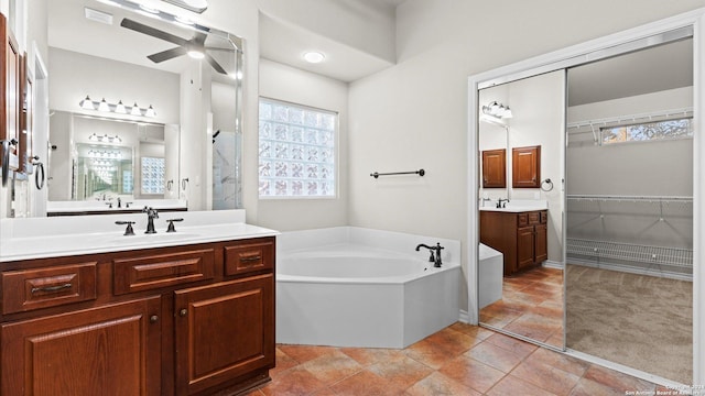 306 Hornpipe Hls, San Antonio, TX 78260 - bathroom featuring a bath, two vanities, a ceiling fan, and healthy amount of natural light